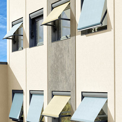 Hausfassade mit mehreren ausgefahrenen Markisen an einem sonnigen Tag