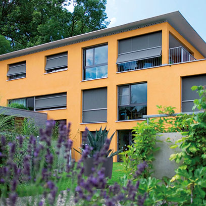 Orangenes Haus mit Fenstern und Ausstellmarkisen