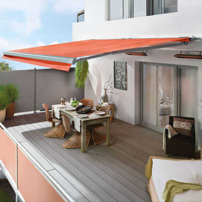 Rote ausgefahrene Markise über einer Sitzgelegenheit auf einer Terrasse
