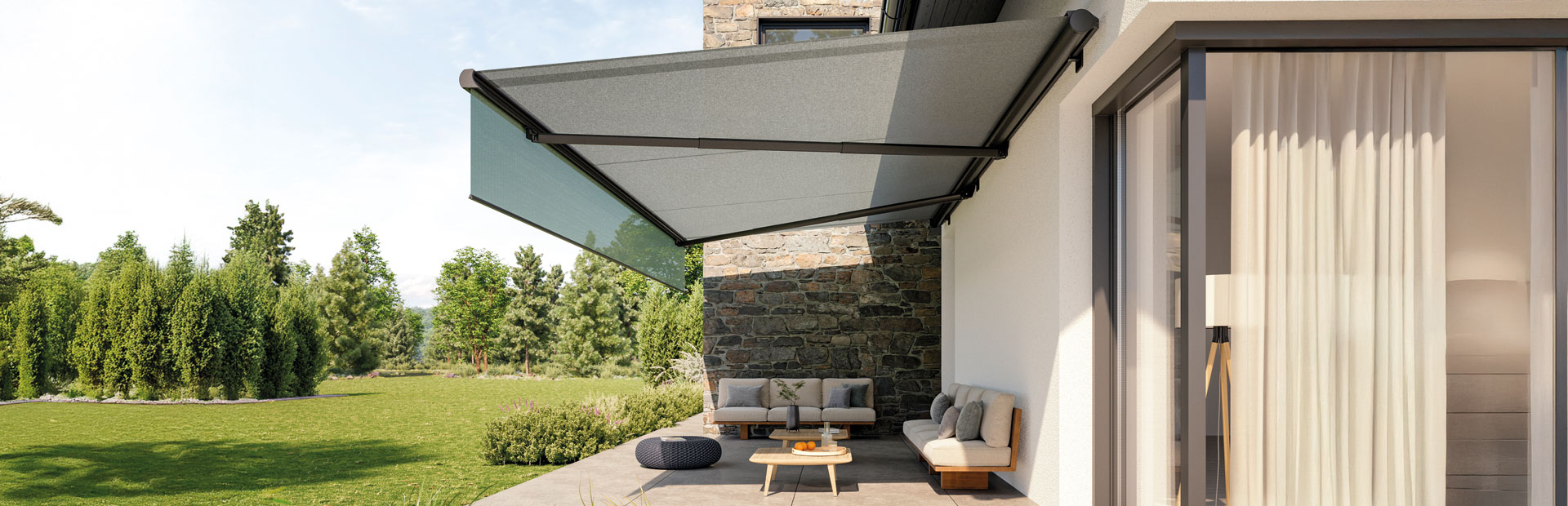 Graue Markise an einer Hauswand über einer großen Terrasse 