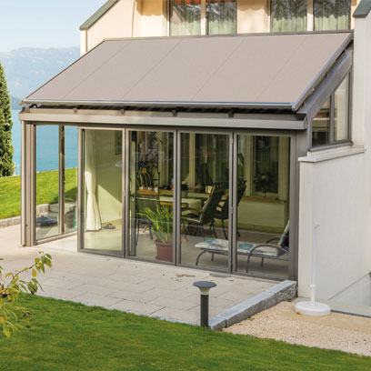 Abgeschrägte Glasdachmarkise mit Frontverglasung an einer Hausfassade