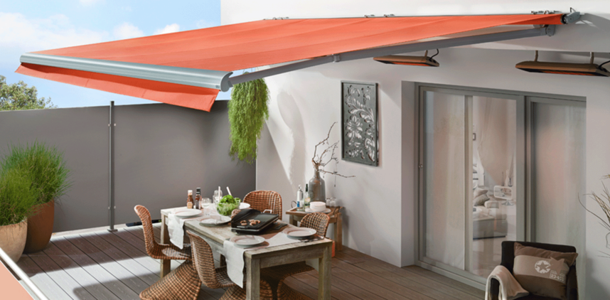 Rote ausgefahrene Markise über einer Sitzgelegenheit auf einer Terrasse