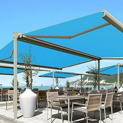 Große Terrasse am Meer mit blaue freistehende Markise und drunter eine Sitzgelegenheit