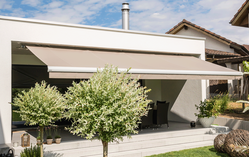 Ausgefahrene Markise an einem Haus mit Garten