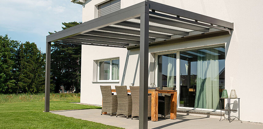 Glasdach an einem Haus mit Terrasse, Garten und Sitzgelegenheit