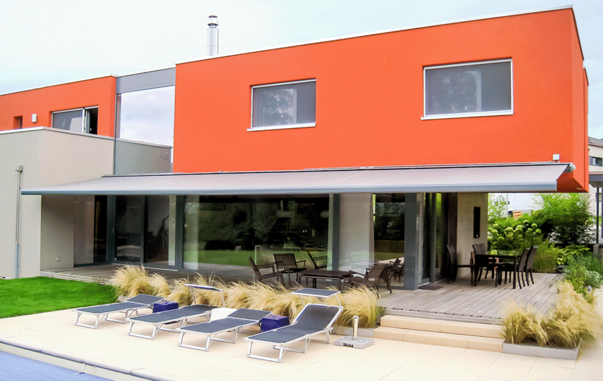 Rotes Haus mit Markise und Pool 