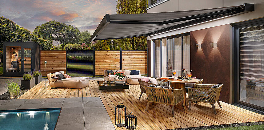 Modernes Wohnhaus mit Terrasse, Garten und ausgefahrener Markise