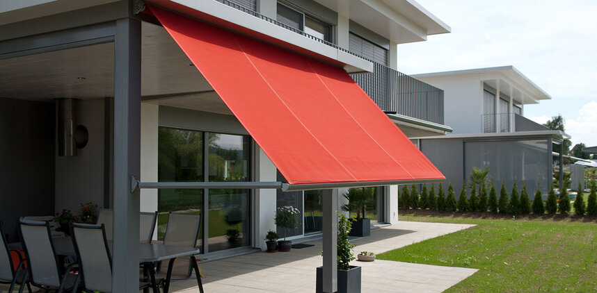 Hausfassade mit ausgefahrener roter Markise